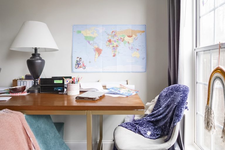 desk with chair and map of the world pinned to the wall