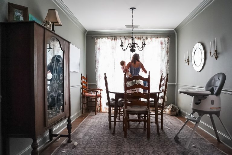 woman holding baby in dining room