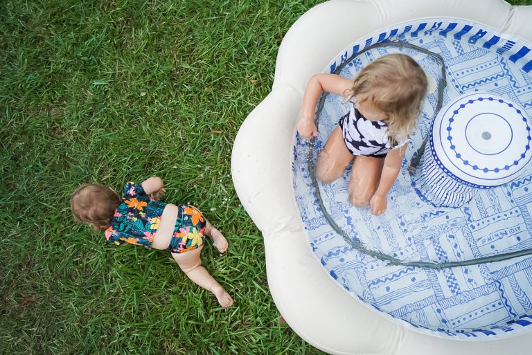Two Kids playing in kiddie pool outside