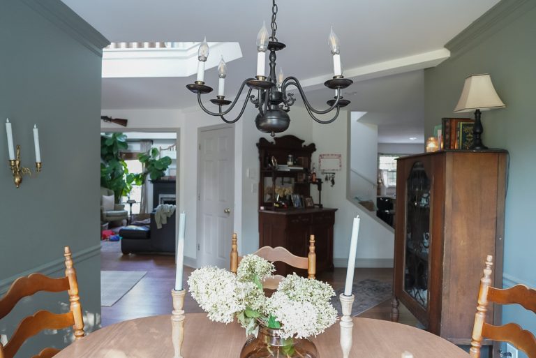 dining room centerpiece with dried hydrangeas looking out onto other rooms filled with antique cottage style furnishings