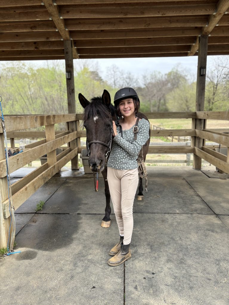 Preteen equestrian with horse before riding