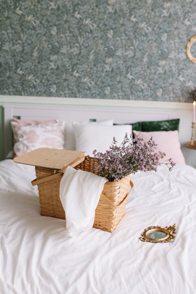 A cozy bedroom scene featuring a wicker basket with flowers on a white bed for a vintage touch.