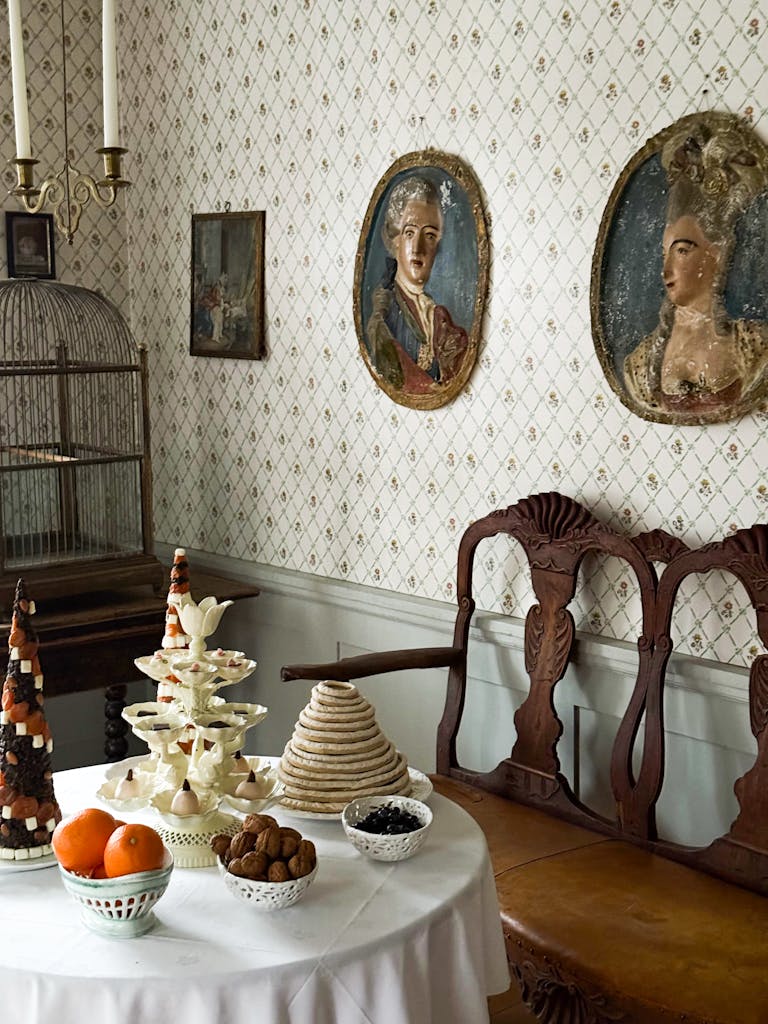 Elegant vintage dining room with decorative treats and antique portraits.